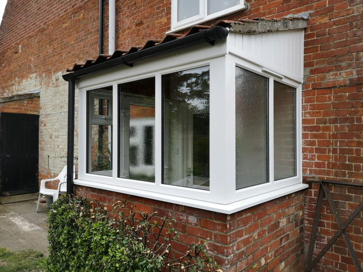 Tiled half-brick porch with side door for this pretty cottage